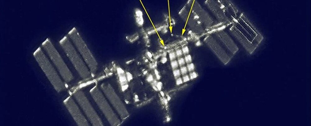 دو فضانورد با دوربین عکاسی در فضا راهپیمایی می‌کنند